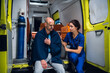 © Anna Kosolapova - Ambulance car, nurse calms down an injured man in a blanket.