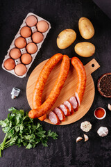 Wall Mural - fresh homemade sausage on a dark background with vegetables