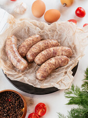 Wall Mural - fresh homemade sausage on a light background with vegetables