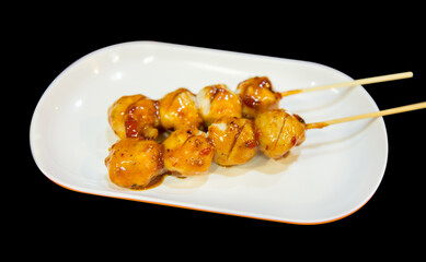 Grilled meatballs or pork on skewers with chili sauce in white plate, focus selective