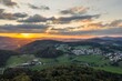 Bild einer Luftaufnahme mit einer Drohne der Stadt Grafenau im bayerischen Wald mit Bergen Arber Rachel und Lusen im Hintergrund während des  Sonnenuntergang, Deutschland