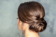 © okskukuruza - Rear view of young brunette woman with beautiful middle bun hairstyle on gray background