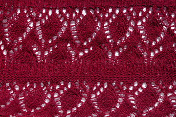 Wall Mural - Knitted texture burgundy fabric abstract background. Dark red wine cloth on light surface for design. Handmade shops cozy backdrop. Wavy ornate textured kashmere woolen or cotton crocheted material.