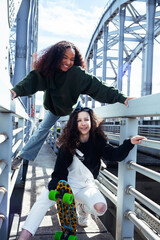 Wall Mural - young cute teenage girls together in industrial zone happy smiling having fun, big city lifestyle fashion people