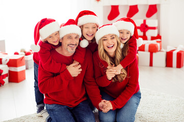 Poster - Portrait of nice attractive lovely careful affectionate big full cheerful cheery glad family mom dad small little kids embracing having fun in light white interior apartment house indoor