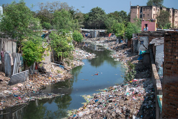plastic waste disposal in a river in the slums of chennai, tamil nadu, india