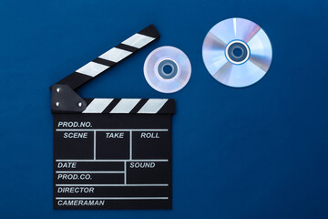 Wall Mural - Film clapper board and cd's on classic blue background. Cinema industry, entertainment. Top view