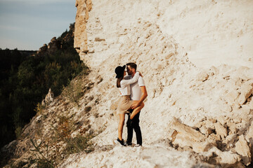 Wall Mural - Couple on summer vacation trip in the mountains. Sincere emotions, passion and love of couple. Photo in the mountains against the backdrop of rocks.