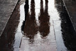 Sombra de un pareja reflejada en el suelo mojado de una calle por la lluvia
