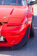 Wall Mural - Front of a red, sports car with closing headlights