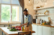 © Svitlana - Young man cook holding, cutting tomatoes while preparing healthy meal with vegetables in the kitchen. Italian cuisine concept