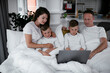 © JustLife - Beautiful parents with kids enjoying at home. Young family watching movie on lap top.