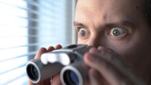 Surprised man with binoculars. Curious guy with big eyes. Nosy neighbour stalking or snooping secrets, gossip and rumour. Silly funny face. Shocked about unbelievable news. Stalker peeping people.