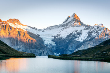 Wall Mural - Bachalpsee lake in Swiss Alps mountains on sunset. Snowy peaks of Wetterhorn, Mittelhorn and Rosenhorn on background. Grindelwald valley, Switzerland. Landscape photography