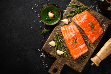 Wall Mural - Salmon fish with ingredients at black table.