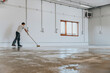 A worker applies the primer to the concrete floor.Epoxy resin project