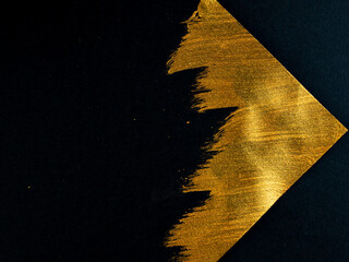 Triangle drawn in gold paint on a black background.