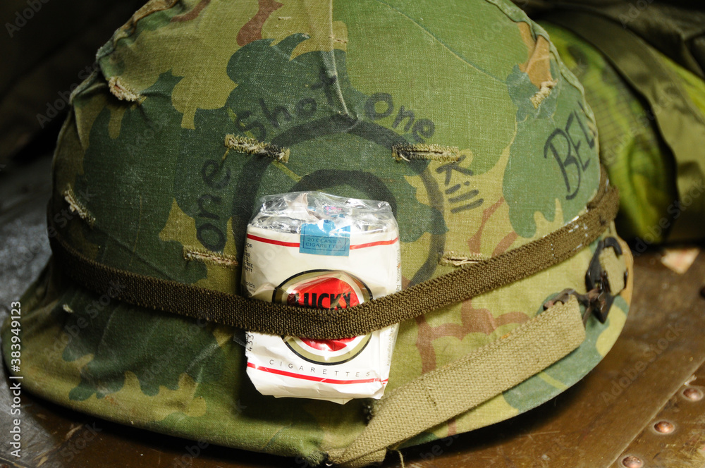 One shot one kill military helmet with Luck Strike cigarettes in its band.  Stock Photo