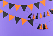 Halloween Background With Garlands And Paper Bats In Traditional Colors Orange And Black On Purple Background