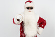 © Dzmitry - Santa Claus in dark glasses points his finger towards the camera. Isolated background. Focusing the image on your finger