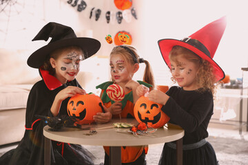 Poster - Cute little kids with pumpkin candy buckets wearing Halloween costumes at home