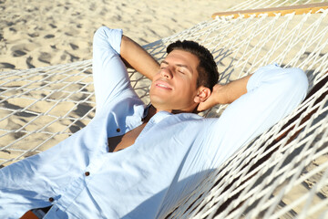 Canvas Print - Handsome man relaxing in hammock on beach