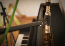 Recording An Upright Piano With A Slim Condenser Microphone On A Stand.