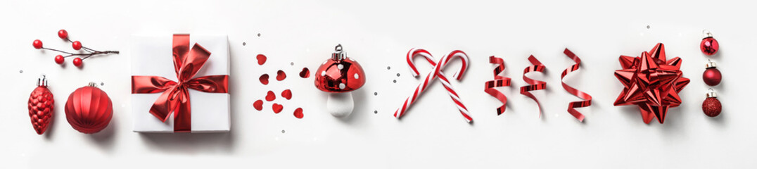 Wall Mural - christmas decoration, gift boxes with red ribbon, sparkles, confetti, christmas candy and balls on w