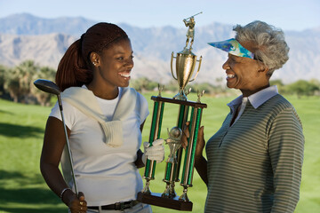 Grandmother and Granddaughter Holding Golf Trophy