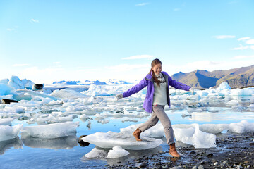 Wall Mural - iceland travel tourist walking on ice looking at view of nature landscape jokulsarlon glacial lagoon