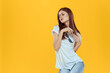 © SHOTPRIME STUDIO - A woman sits on a chair and holds dark glasses in her hands a white t-shirt womens fashion clothes yellow background