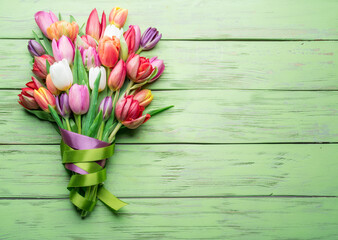 Wall Mural - Colorful  bouquet of tulips on green wooden background.