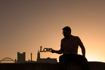 Wall Mural - man next to newcastle city skyline silhouette