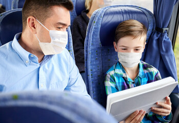 Sticker - tourism, health and people concept - father and son wearing face protective medical masks for protection from virus disease with tablet pc computer sitting in travel bus