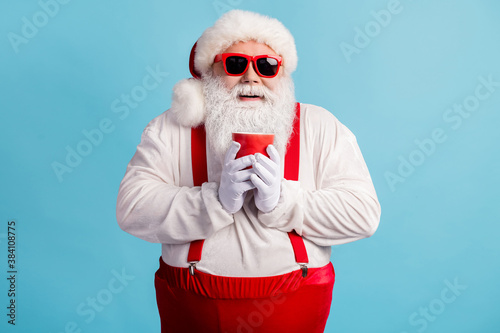 Portrait of his he nice attractive cheerful cheery white-haired Santa enjoying drinking warm cacao eggnog Eve Noel festive isolated bright vivid shine vibrant blue color background