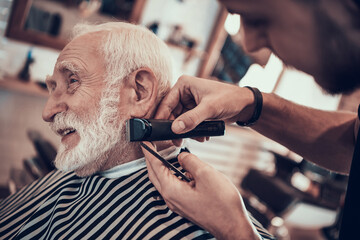 A young master makes a beard for an old man. 