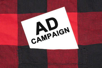 Poster - White business card with text Ad Campaign lies in the sleeve of a checkered shirt