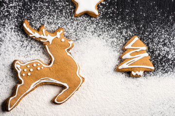 Wall Mural - Top view of cookies in shape of deer, pine and star with sugar powder