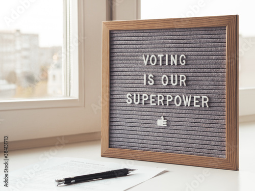 Letter board with phrase Voting is our superpower. Announcement of USA Presidential Election at 3rd November 2020. Call to go to the vote. Paper ballot and pen on window sill.