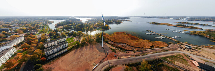 Aerial panoramic view of the largest finnish flag in the world and the tallest flagpole in Europe against of Hamina city, Finland. The flag pole is 100 meter high.