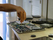 © David Martínez - Mano sujetando un destornillador arreglando la placa base de un ordenador