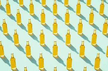 Leinwandbilder - Rows of full beer bottles against light blue surface.