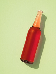 Leinwandbilder - One transparent glass bottle with metal cap laying on light green surface.