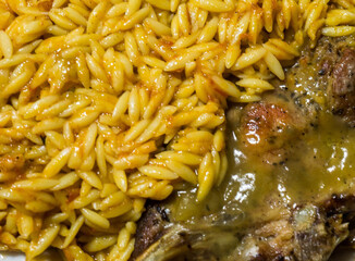 a plate of yellow barley with a cooked steak 