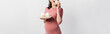 © LIGHTFIELD STUDIOS - panoramic crop of pregnant woman holding plate while eating cupcake isolated on white