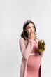 © LIGHTFIELD STUDIOS - pregnant woman holding jar with pickled cucumbers while licking finger isolated on white