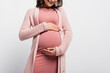 © LIGHTFIELD STUDIOS - cropped view of joyful pregnant woman touching belly isolated on white