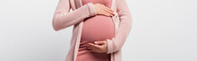 panoramic crop of pregnant woman touching belly isolated on white