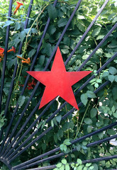 Red metal figure in the shape of a star on the gate in the Park