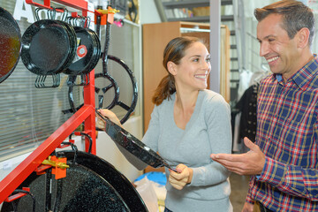 couple choosing pans for cooking at the supermarket